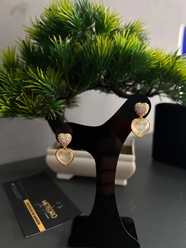 Brincos Coração Cristal. Corações com detalhes cintilantes e pingente em tom claro.